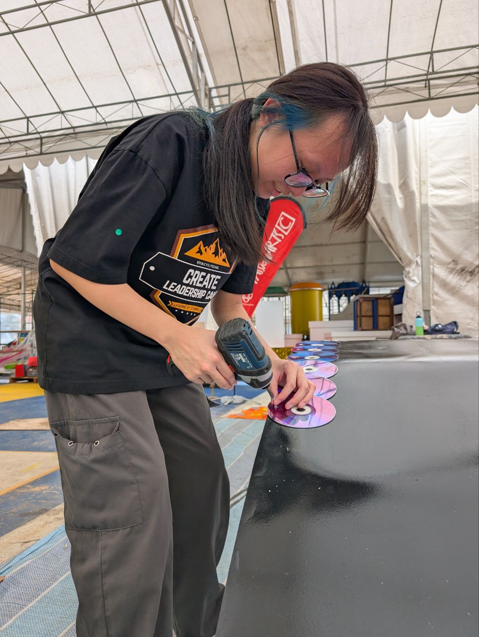 Use of recycled CDs donated by People's Association for installation onto the headphones of the float