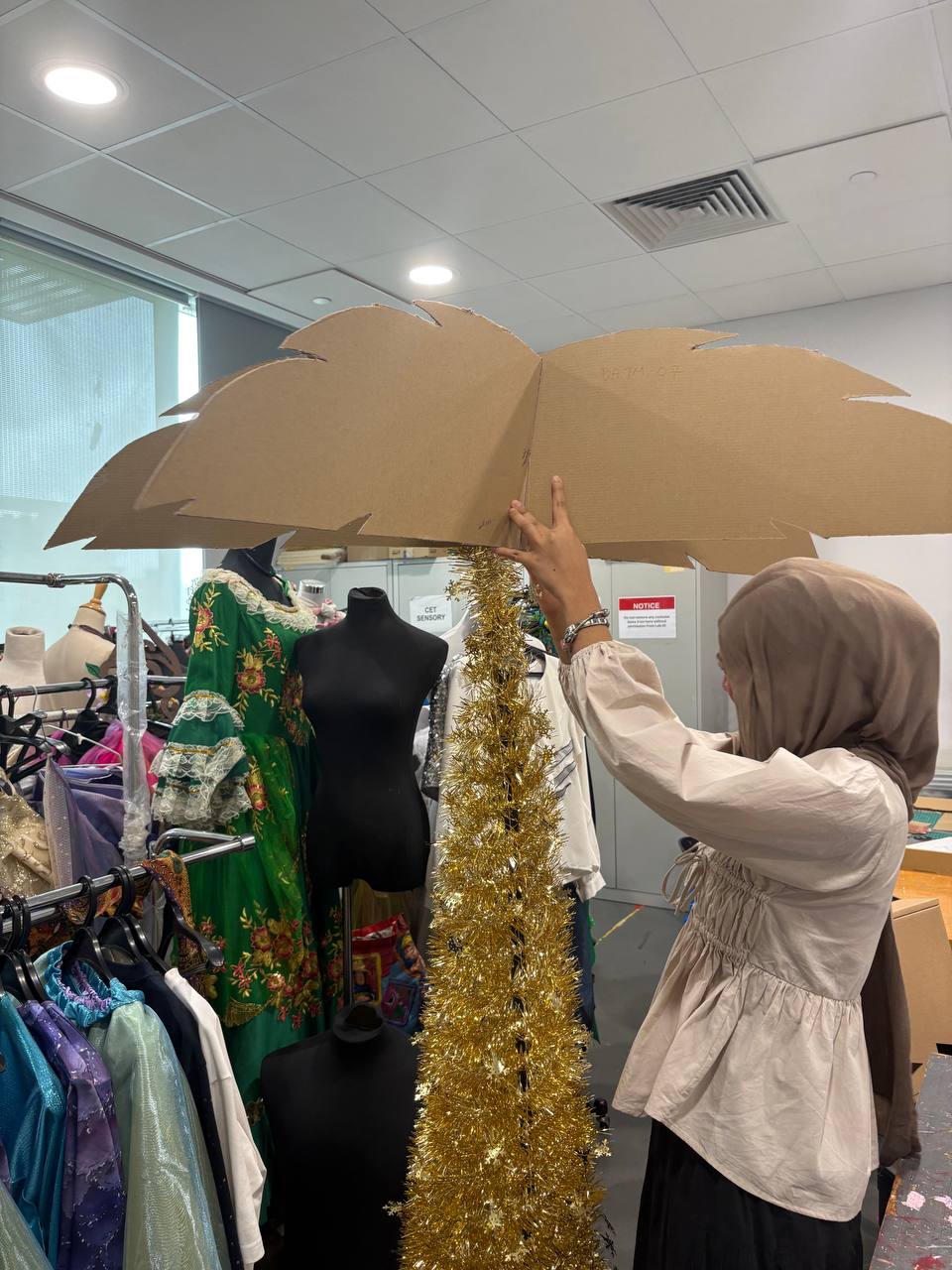 designing our tree with cardboard as leaves and collapsible poles as the trunk